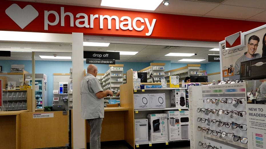 A man stands at the pharmacy counter at CVS Pharmacy