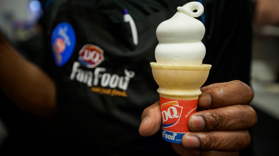 A Dairy Queen employee displays an ice cream cone for a photograph at a DQ Grill & Chill restaurant ahead of its grand opening in the Manhattan borough of New York, on May 28, 2014.