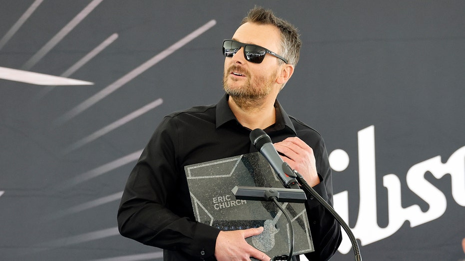 Eric Church holds an award