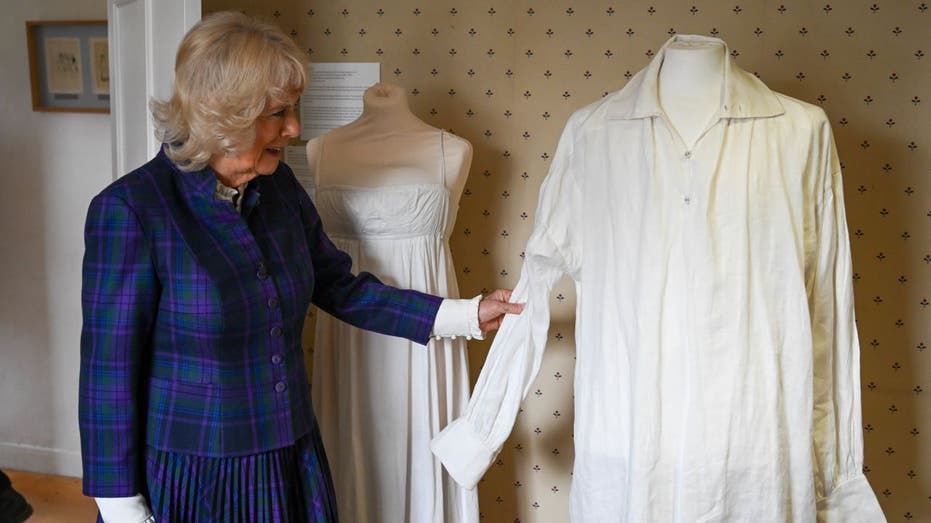Camilla, Duchess of Cornwall touching Colin Firth's shirt on display