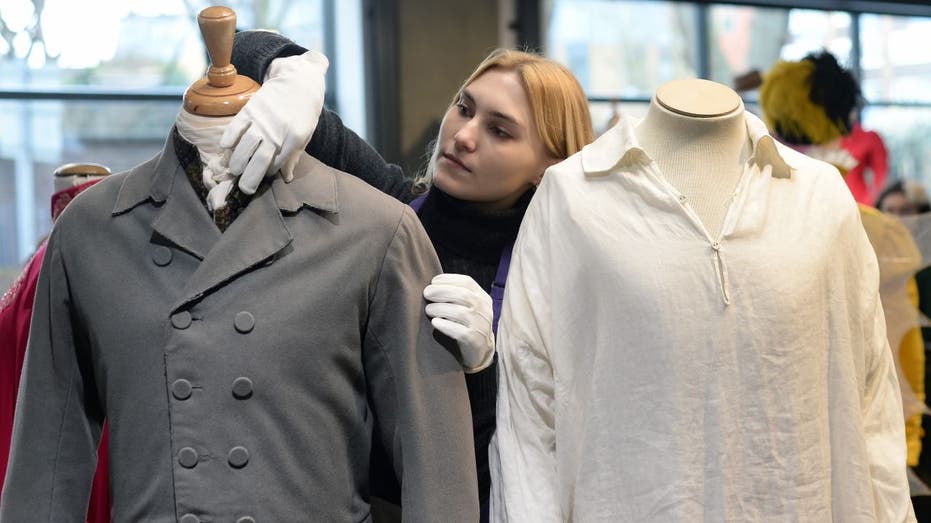 Worker handling shirts on display