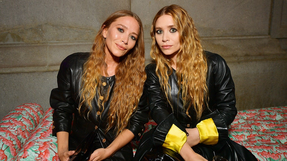 Mary-Kate and Ashley Olsen sitting next to each other