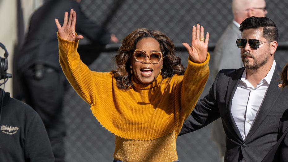 Oprah Winfrey waving with both hands outside Jimmy Kimmel Live