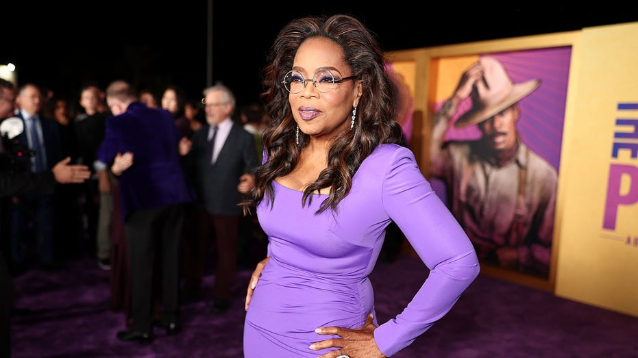 Oprah Winfrey showcasing slim figure on The Color Purple red carpet