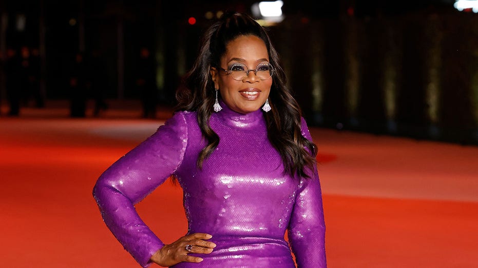 Oprah Winfrey posing with hand on hip on red carpet