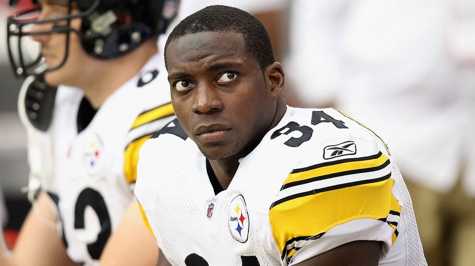 Rashard Mendenhall in a Steelers jersey looks up while sitting on the bench