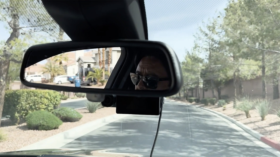 A man's face in the rearview mirror