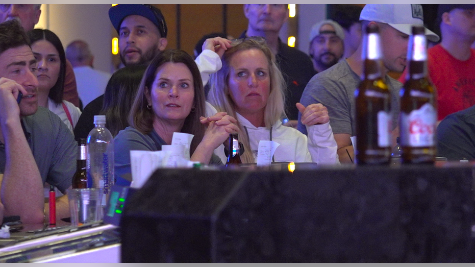 Two females watch the basketball game