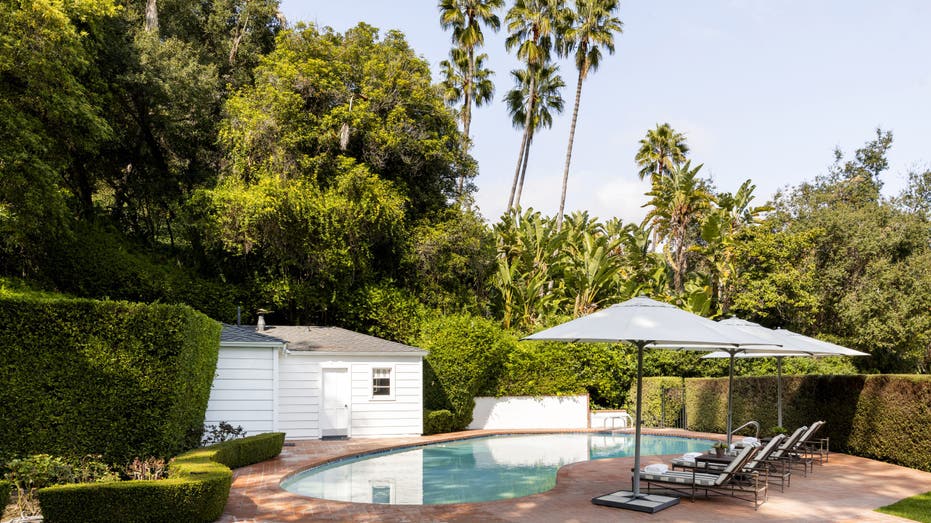 A pool in the backyard with a white large shed