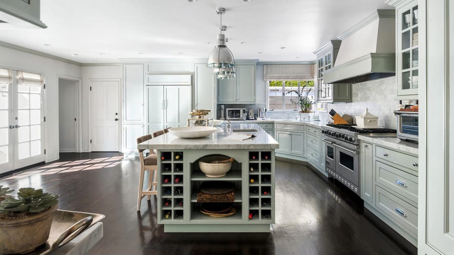 Light mint green cabinets and white marble countertops in Judy Garland's old kitchen