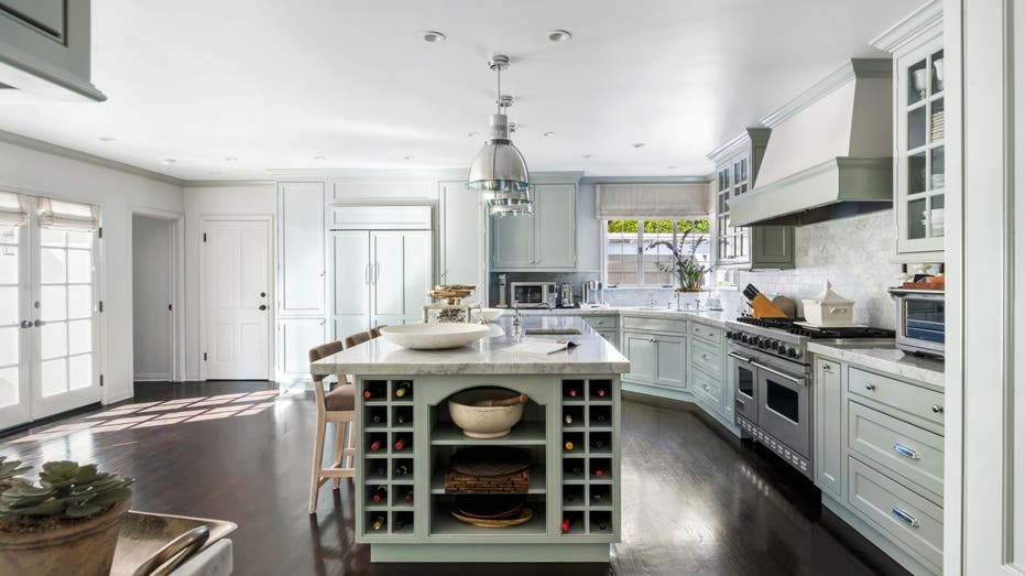 Light mint green cabinets and white marble countertops in Judy Garland's old kitchen