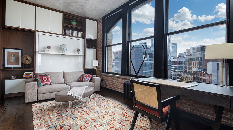 A room with custom shelving and a big window.