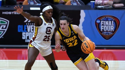 Caitlin Clark #22 of the Iowa Hawkeyes dribbles around Raven Johnson #25 of the South Carolina Gamecocks in the second half during the 2024 NCAA Women's Basketball Tournament National Championship at Rocket Mortgage FieldHouse on April 07, 2024 in Cleveland, Ohio.