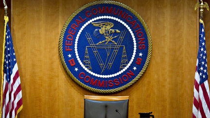 The Federal Communications Commission (FCC) seal hangs inside a meeting room at the headquarters ahead of a open commission meeting in Washington, D.C., U.S., on Thursday, Dec. 14, 2017. The FCC is slated to vote to roll back a 2015 utility-style classification of broadband and a raft of related net neutrality rules, including bans on broadband providers blocking and slowing lawful internet traffic on its way to consumers. 