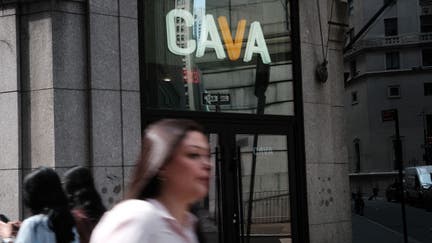 NEW YORK, NEW YORK - JUNE 15: People walk by the Mediterranean restaurant chain Cava is displayed as the company goes public on the New York Stock Exchange (NYSE) on June 15, 2023 in New York City. Cava priced its IPO at $22 per share, valuing the company at $2.5 billion. (Photo by Spencer Platt/Getty Images)
