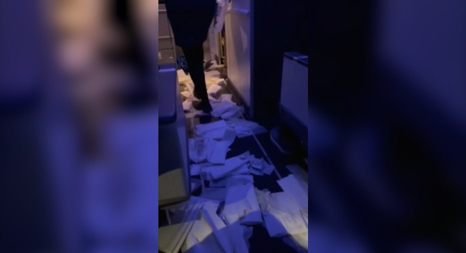 women walks over paper laid out on ground during airplane flooding