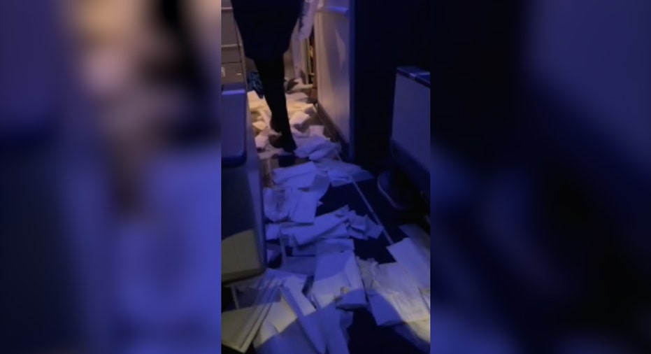 women walks over paper laid out on ground during airplane flooding