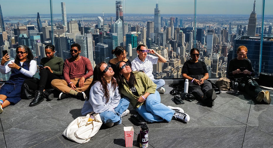 People look toward the sky at the 'Edge at Hudson Yards' observation deck ahead of a total solar eclipse