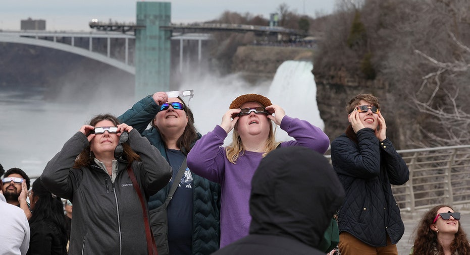People look to the sky ahead of a total solar eclipse at Niagara Falls