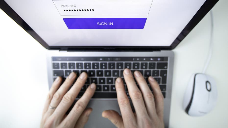 Person entering password on laptop