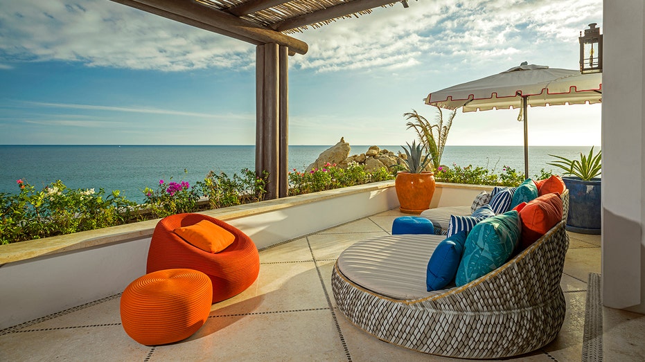 A terrace overlooking the ocean, with colorful furniture.