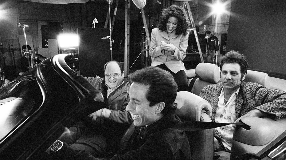The cast of Seinfeld sits in a car on set