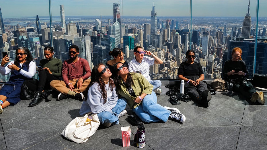 People look toward the sky at the 'Edge at Hudson Yards' observation deck ahead of a total solar eclipse