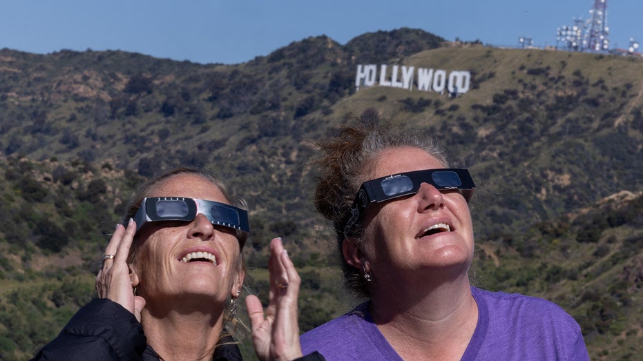 Australian tourists Sharon Bucklee and Nikki Conway join the crowd of solar eclipse watchers at Griffith Observatory