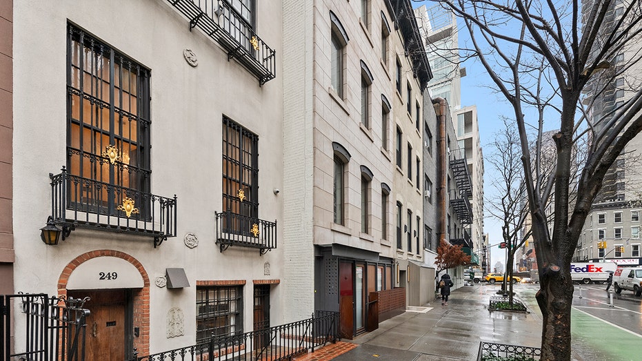 A New York sidewalk featuring the outside of the townhouse.