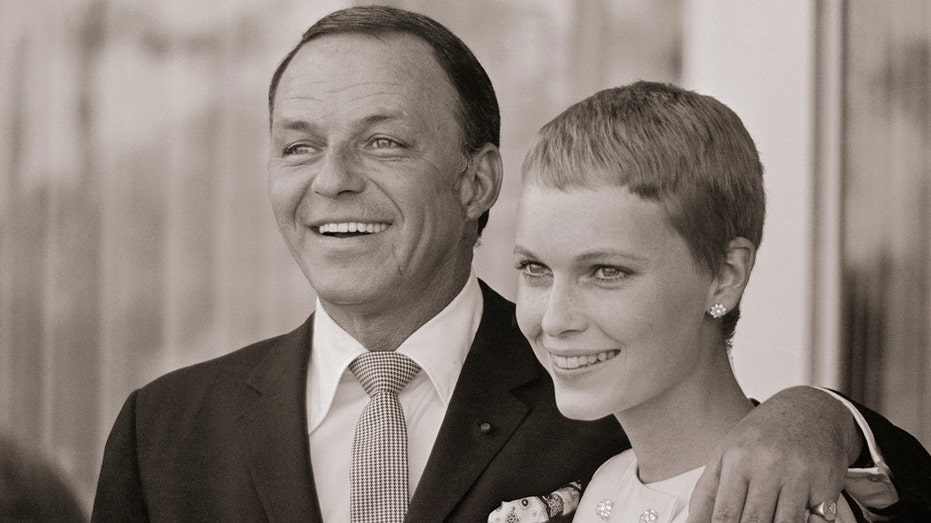 Black and white picture of Frank Sinatra and Mia Farrow hugging