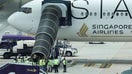 Airport officials gather near the aircraft ladder attached to Singapore Airlines Flight 321 after it landed at Suvarnabhumi International Airport, in Bangkok, Thailand, on Tuesday, May 22. 