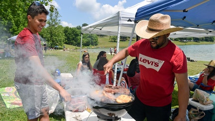 Bern twp., PA - Paulo Rodredo, left, and Ney Santos, right, of Philadelphia, at the grill Saturday afternoon. At the Blue Marsh Lake Dry Brooks Day Use Area in Bern Township for the 4th of July Saturday afternoon July 4, 2020.