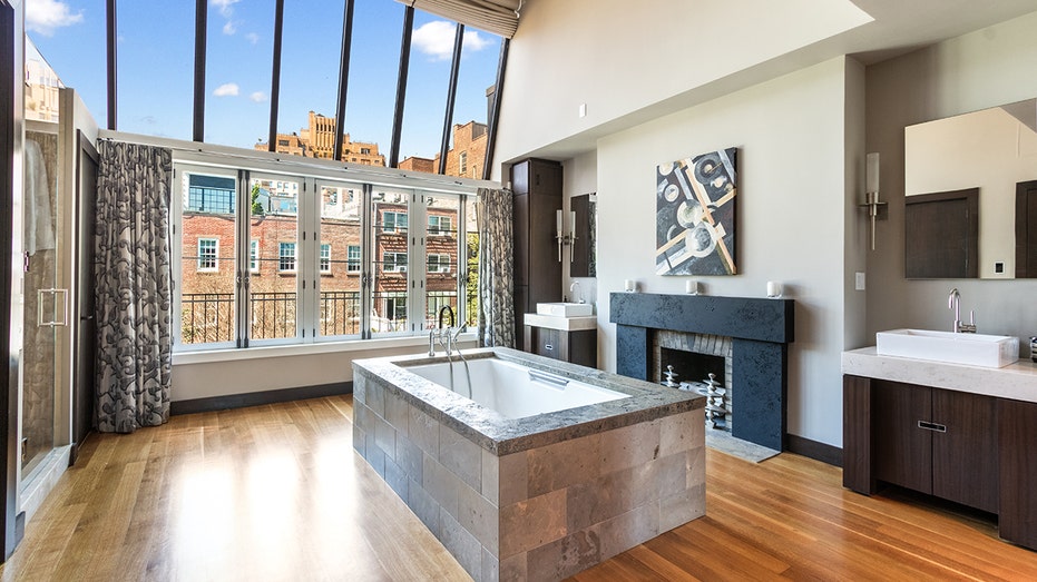 Primary bathroom with a soaking tub and skylight