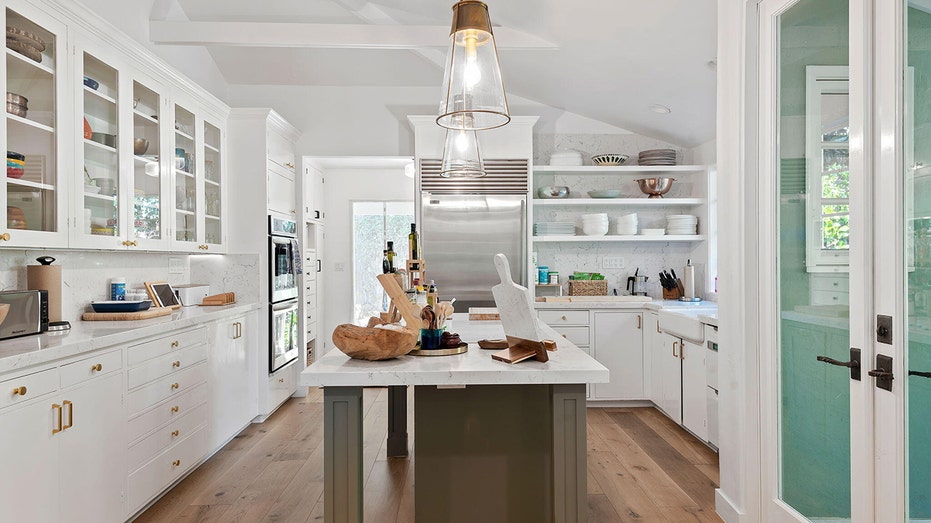 The all-white kitchen features stainless steel appliances and plenty of storage space.