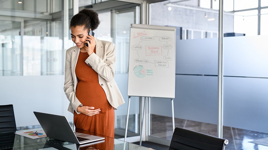 woman works in an office while pregnant