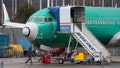 A person walks past an unpainted Boeing 737-8 MAX parked at Renton Municipal Airport adjacent to Boeing's factory in Renton, Washington on Jan. 25 2024. 