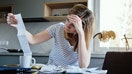 Woman looking at paper bill and counting expenses, Planning budget and home finance management

