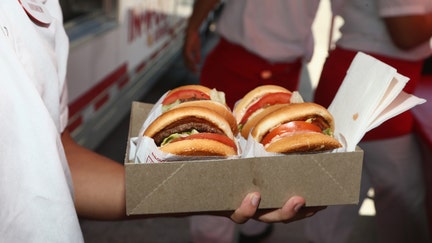 An In-N-Out Burger employee holds up an order on April 23, 2017, in Culver City, California.  - Fox Business News