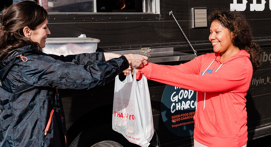 a volunteer hands a meal over to a customer