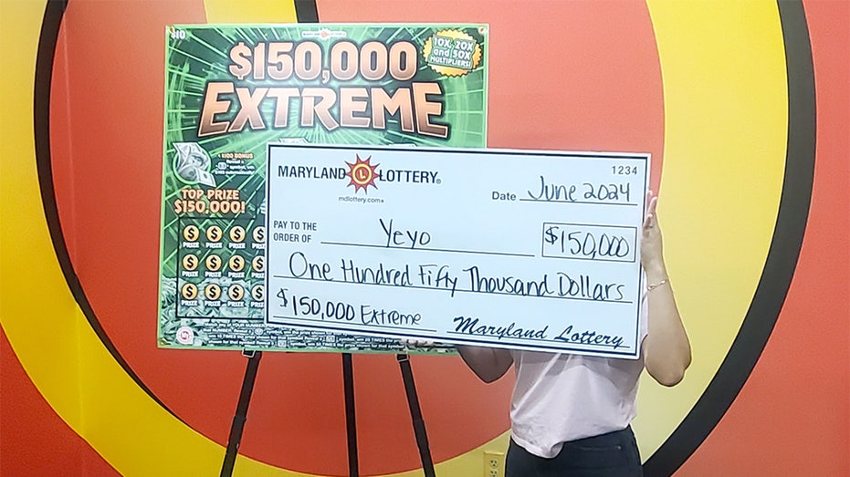 woman hiding her identity behind large check for $150,000