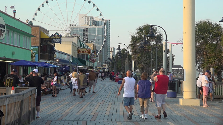 Summer tourists explore the boardwalk in Myrtle Beach