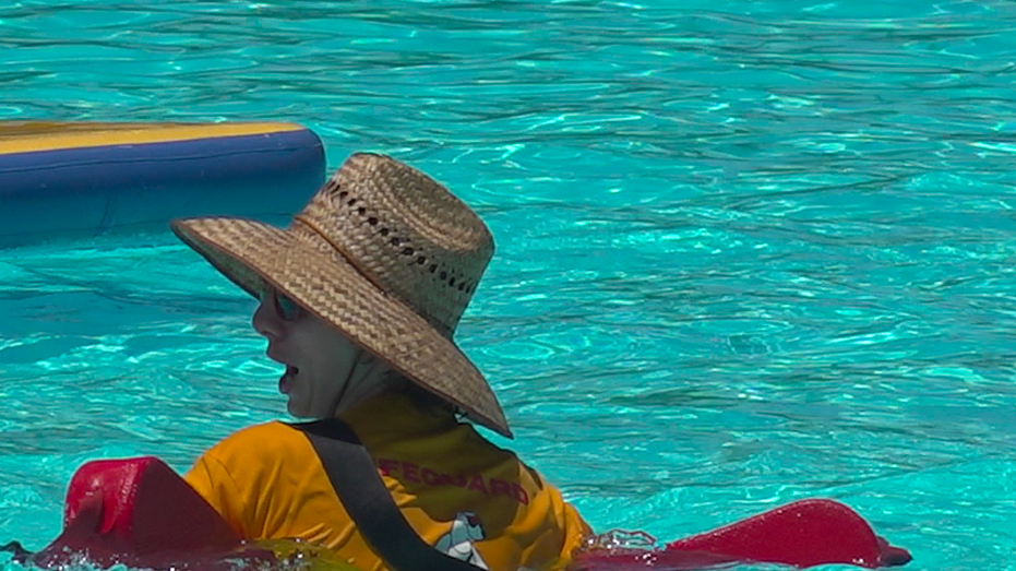 A boy in the water holding a floating device