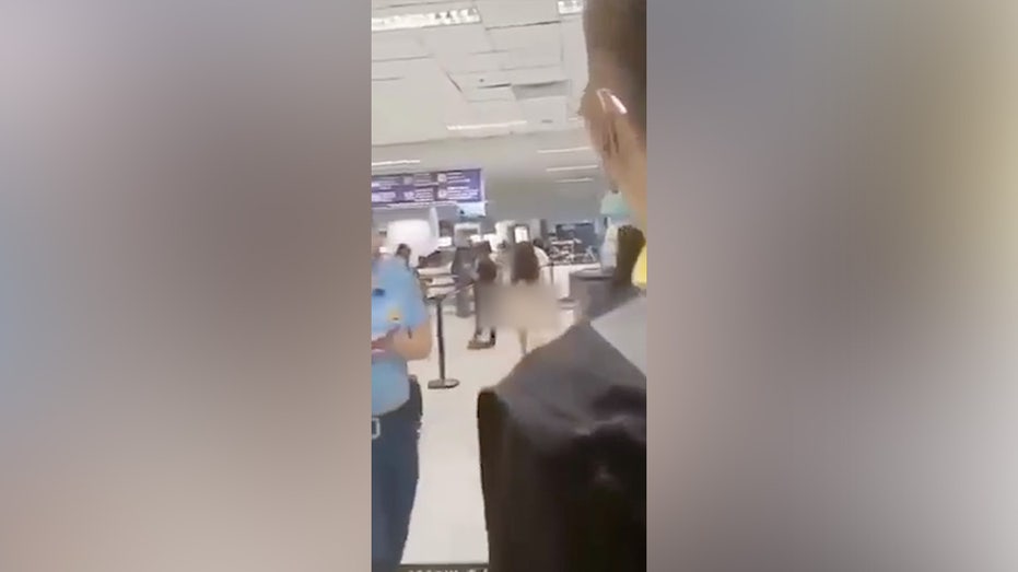 A naked woman is seen walking through security at Ninoy Aquino International Airport.