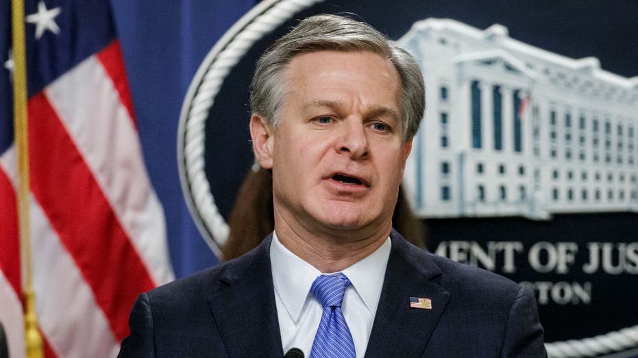 Christopher Wray speaks at a press conference