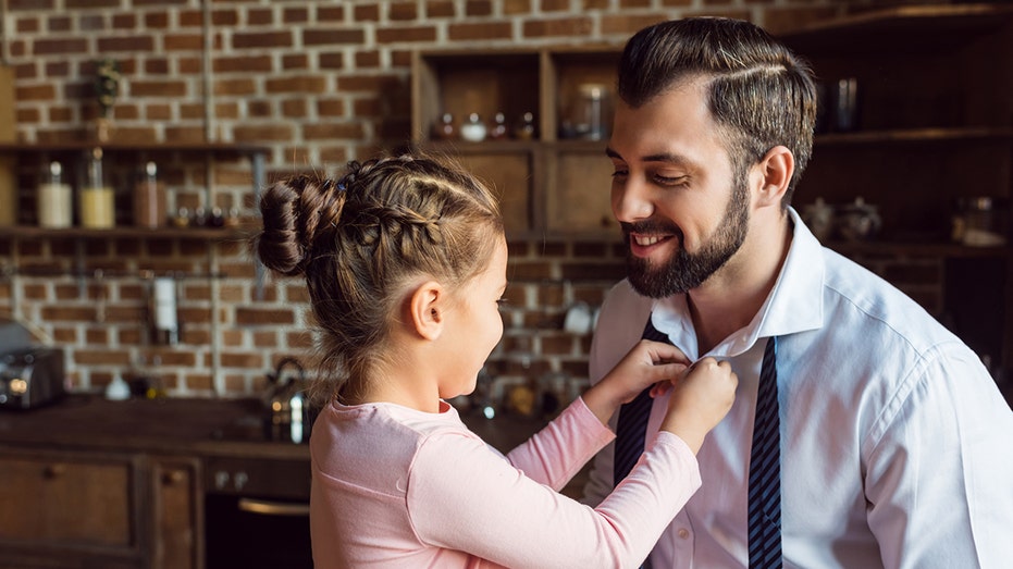 Daughter helping father with tie