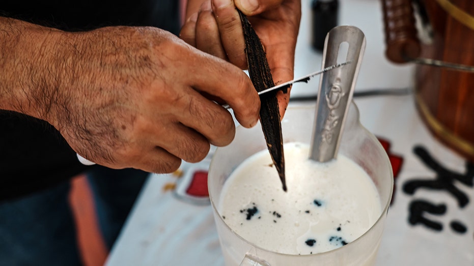 Man extracting vanilla from beans