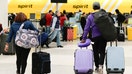 Travelers wheel luggage toward Spirit Airlines check-in desk at George Bush Intercontinental Airport, Tuesday, Nov. 21, 2023, in Houston. - Fox Business News