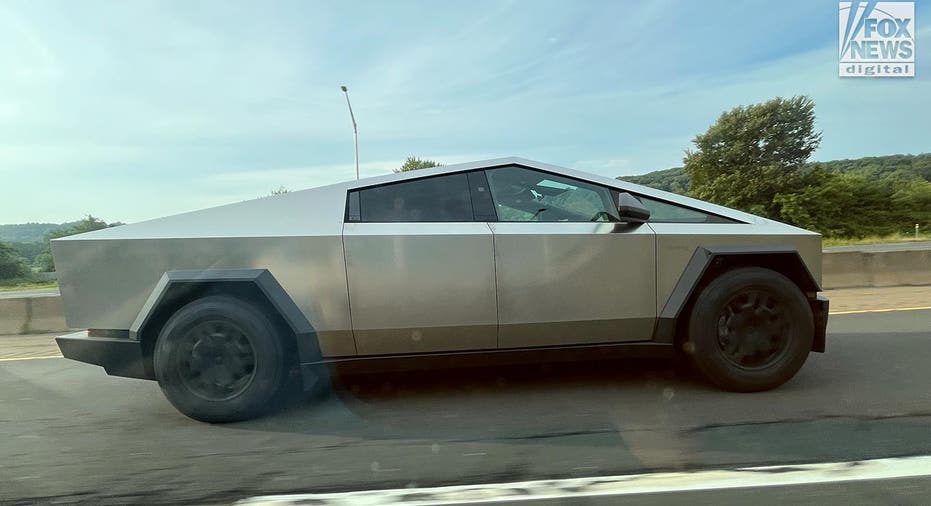 A Tesla Cybertruck drives along a highway