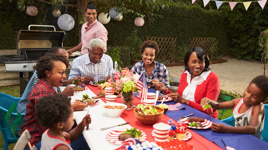 Multi generation black family at table for 4th July barbecue stock photo