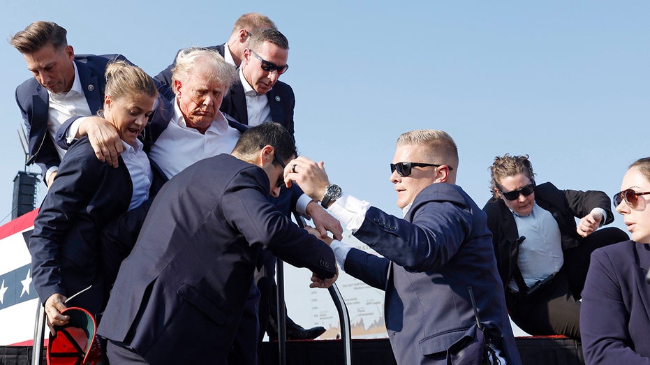 Donald Trump is rushed offstage during a rally